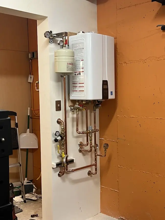 Plumbing technician inspecting water heater connections in Crestwood